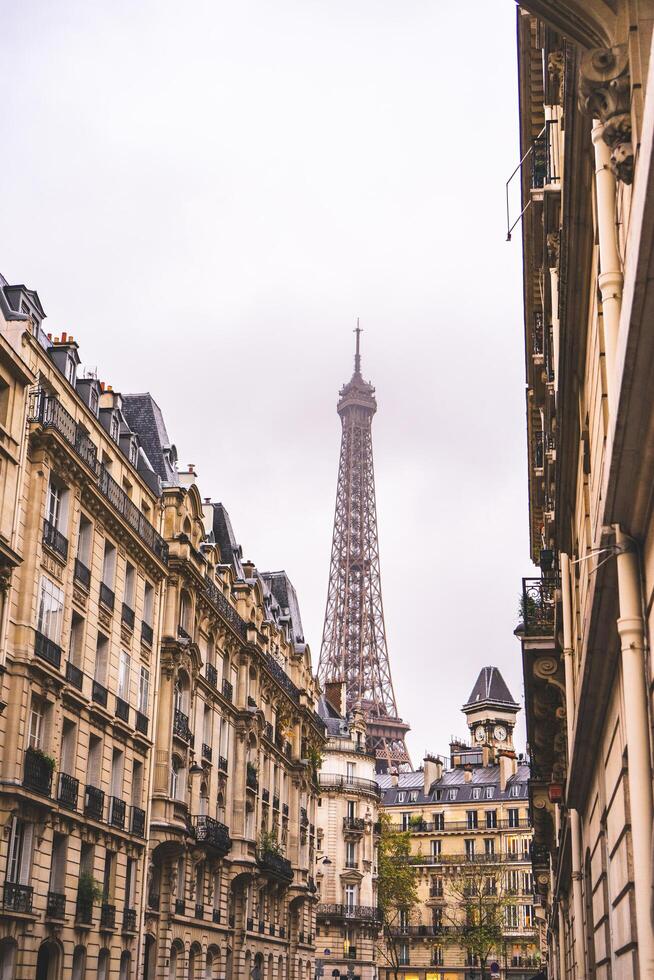 Haut de le tour Eiffel avec vieux bâtiments dans le premier plan. Paris, France, octobre 22 2023. photo