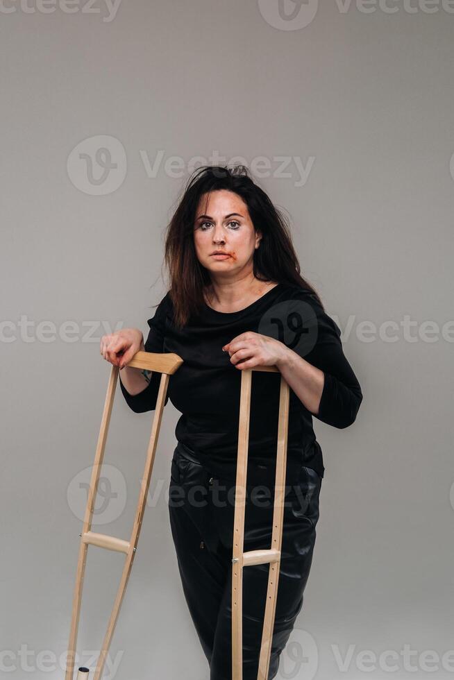 une battu femme dans noir vêtements avec roulettes dans sa mains sur une gris Contexte photo