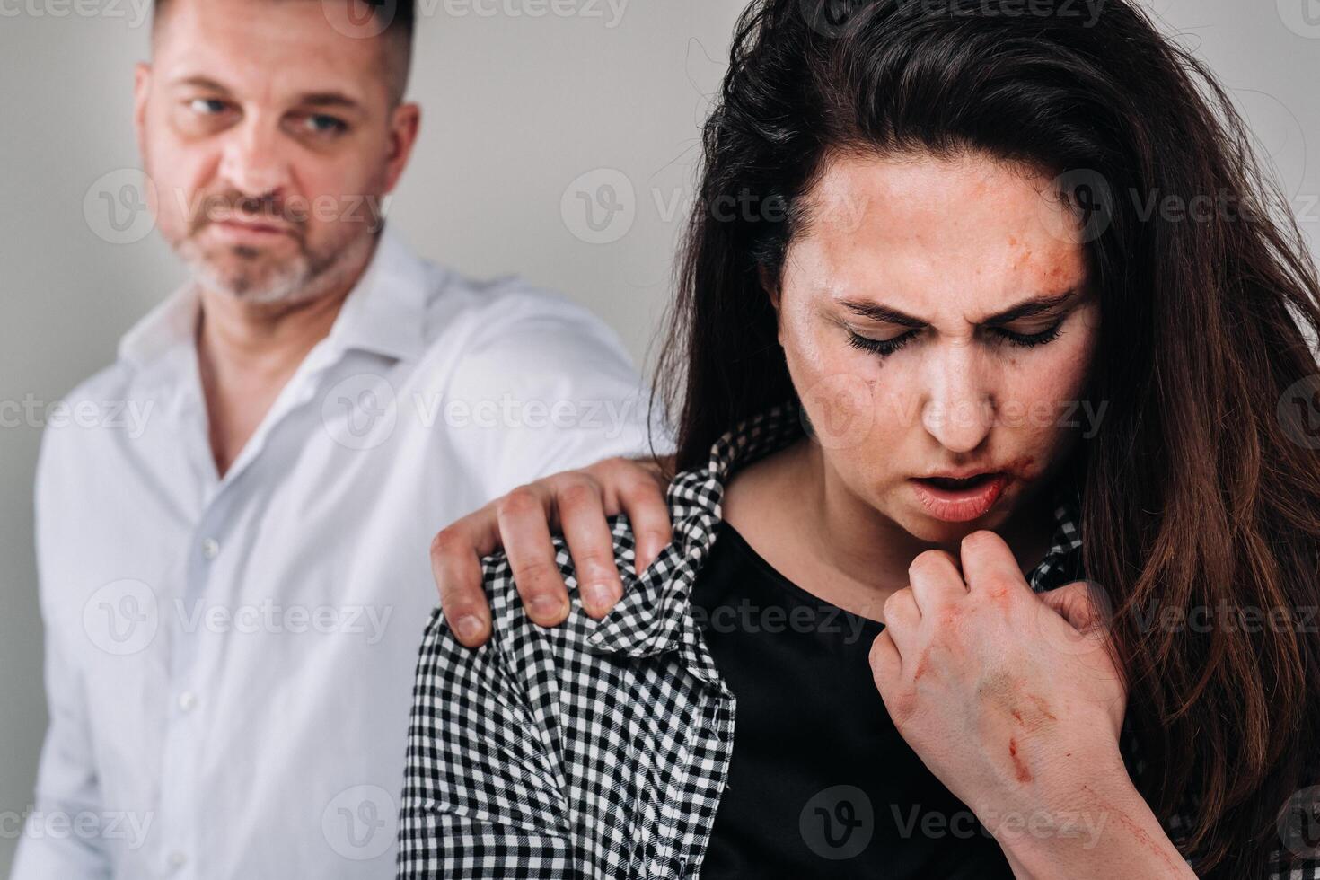 le Masculin violeur mettre le sien main sur le épaule de le battu femme sur une gris Contexte. national la violence photo