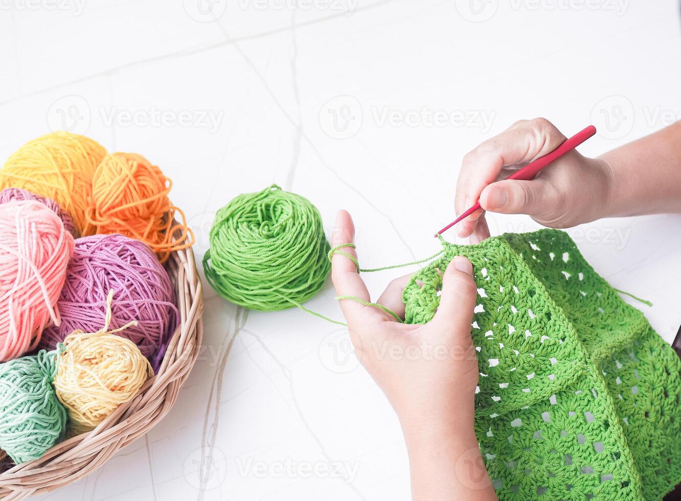 fermer de femme main tricot avec vert la laine photo