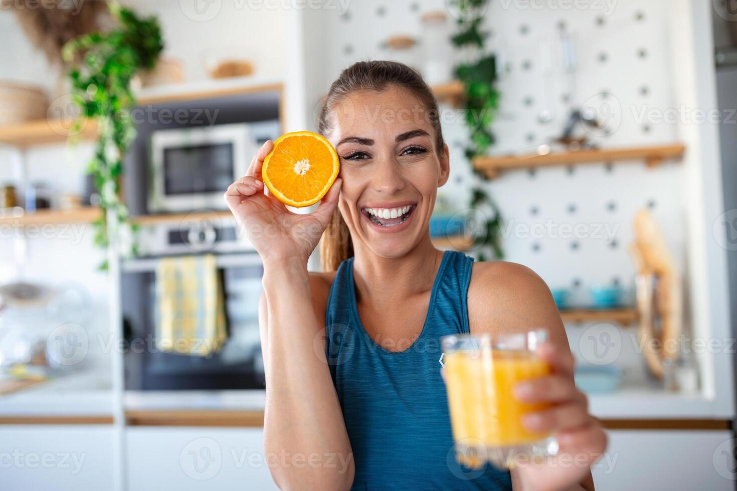 magnifique Jeune femme en buvant Frais Orange jus dans cuisine. en bonne santé régime. content Jeune femme avec verre de jus et Orange à table dans cuisine. photo