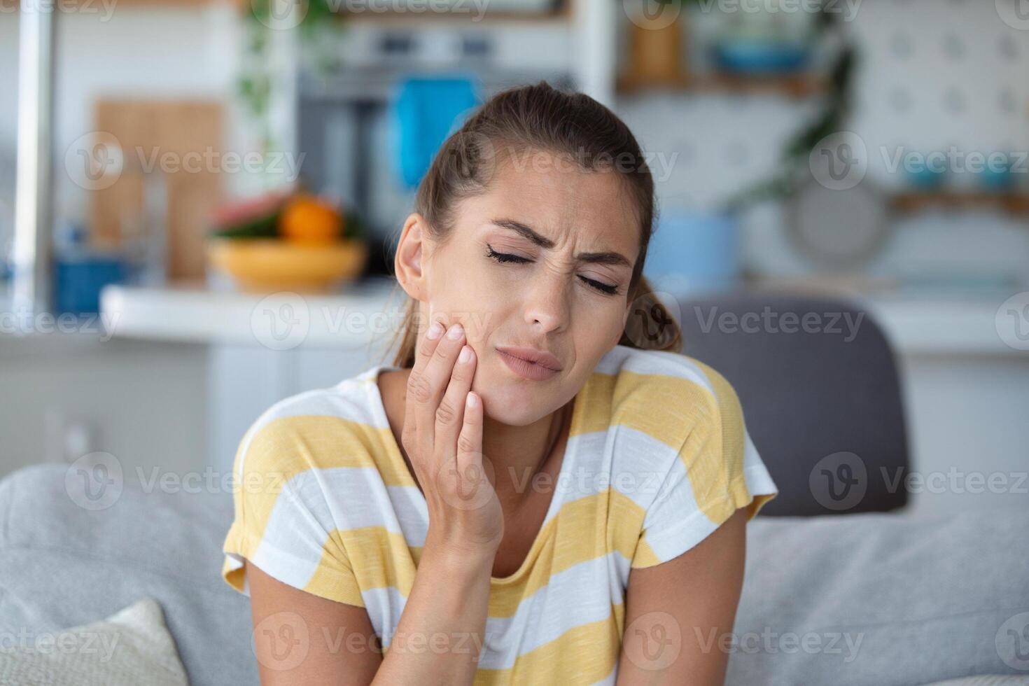 portrait de malheureux Jeune femme Souffrance de mal aux dents à maison. soins de santé, dentaire santé et problème concept. photo