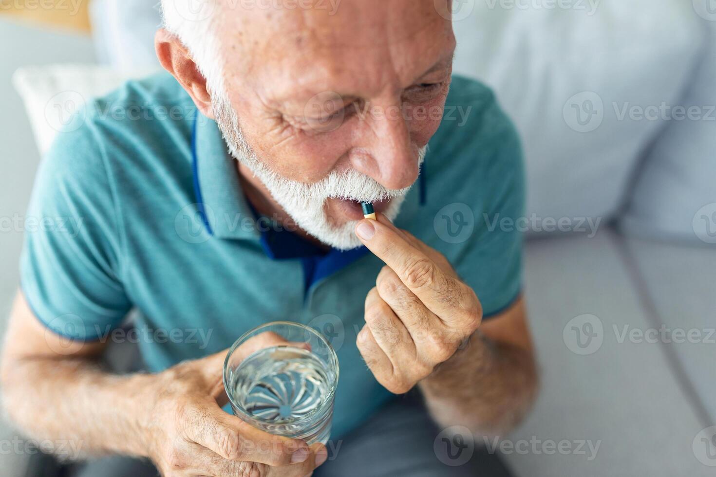 Sénior homme prend pilule avec verre de l'eau dans main. stressé mature homme en buvant sous sédatif antidépresseur Médicaments. homme se sent déprimé, prise drogues. médicaments à travail photo