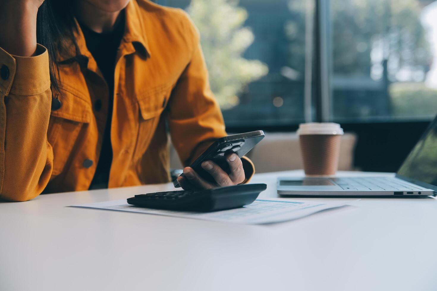 femme d'affaires asiatique en costume formel au bureau heureuse et joyeuse lors de l'utilisation d'un smartphone et du travail photo