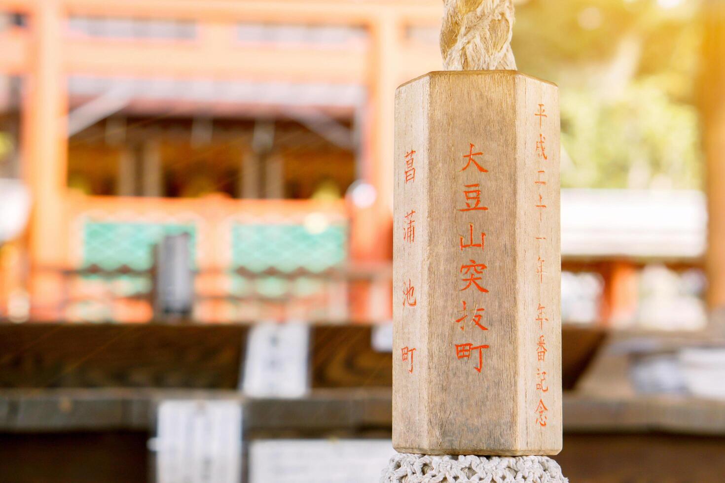 nara ville, Japon, 2018 - fermer en bois manipuler de corde être sur floue Japonais tombeau avec Soleil éclater Contexte. photo