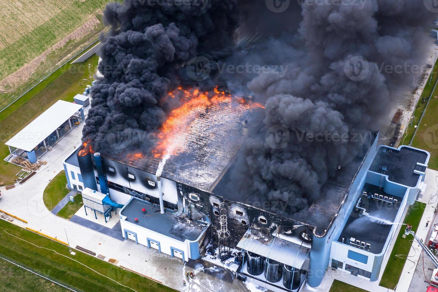 aérien vue de brûlé industriel entrepôt ou logistique centre bâtiment après gros Feu avec énorme fumée de brûlé toit photo