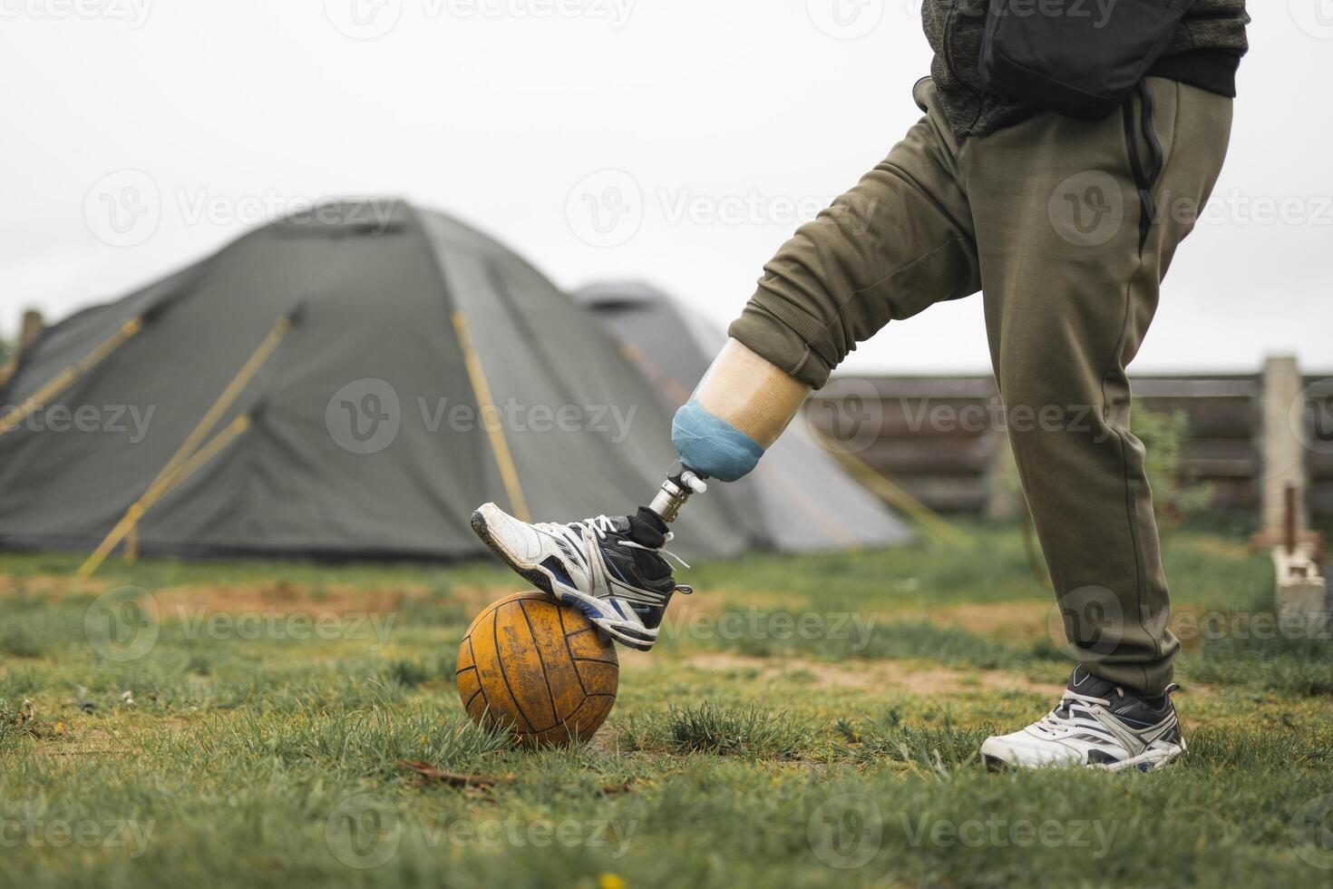 une homme avec une prothétique jambe est Faire des sports en jouant Football photo