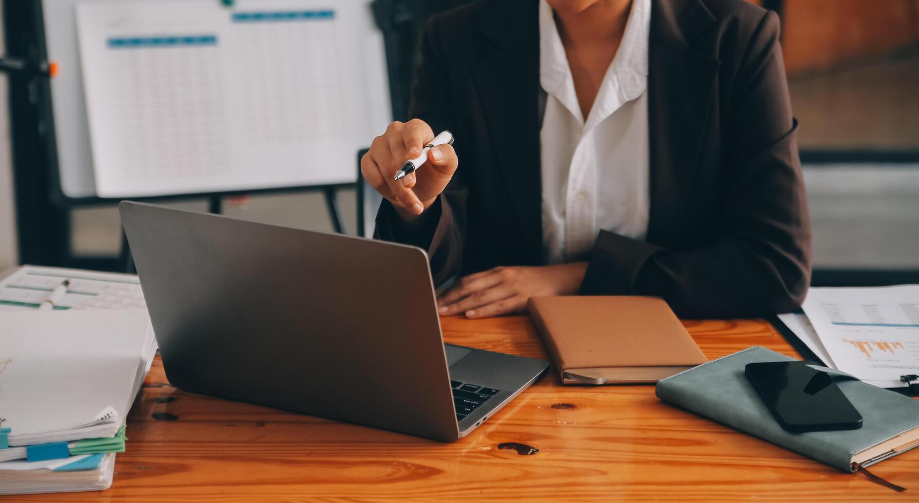 femme d'affaires asiatique en costume formel au bureau heureuse et joyeuse lors de l'utilisation d'un smartphone et du travail photo