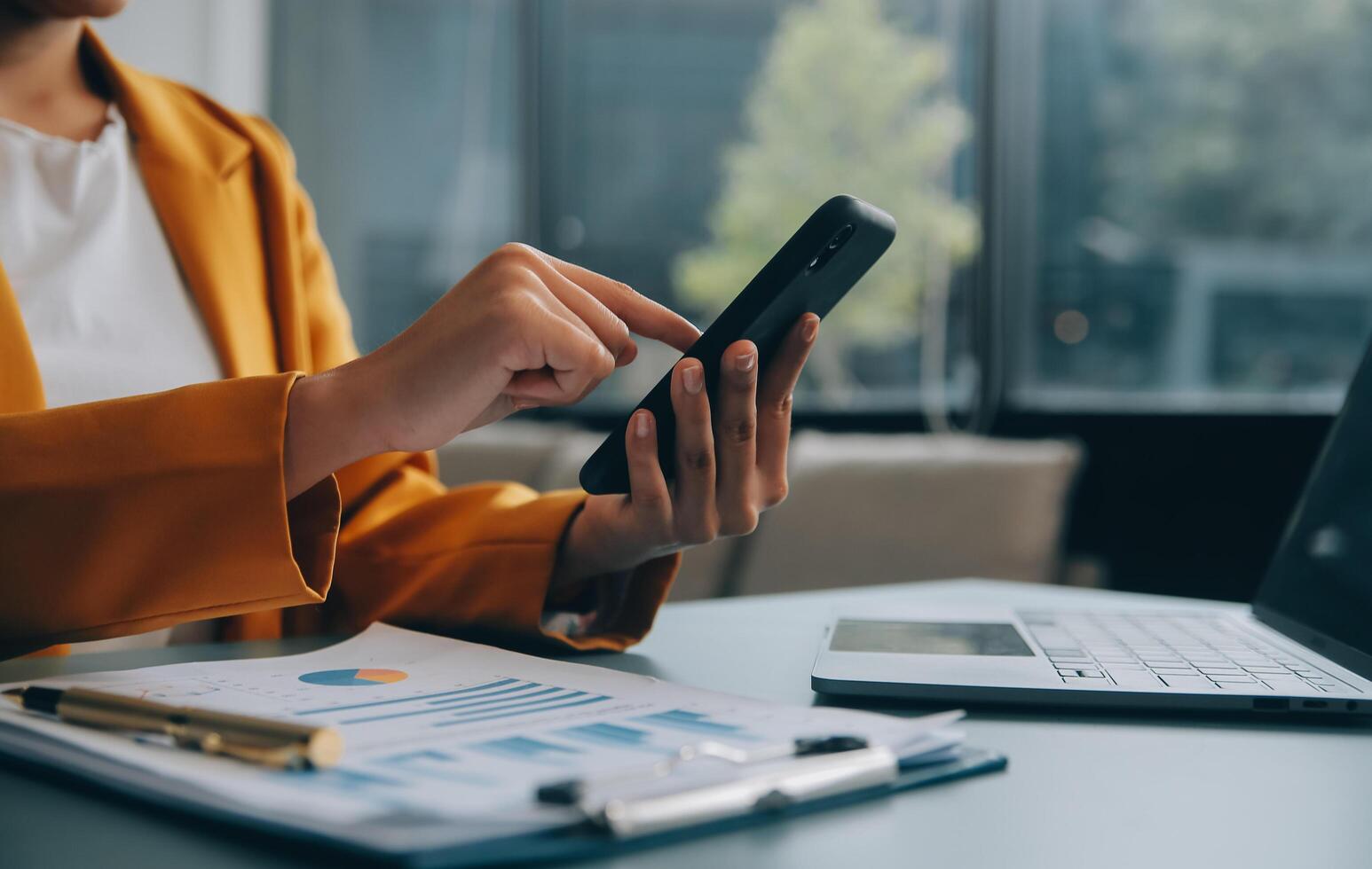 femme d'affaires asiatique en costume formel au bureau heureuse et joyeuse lors de l'utilisation d'un smartphone et du travail photo