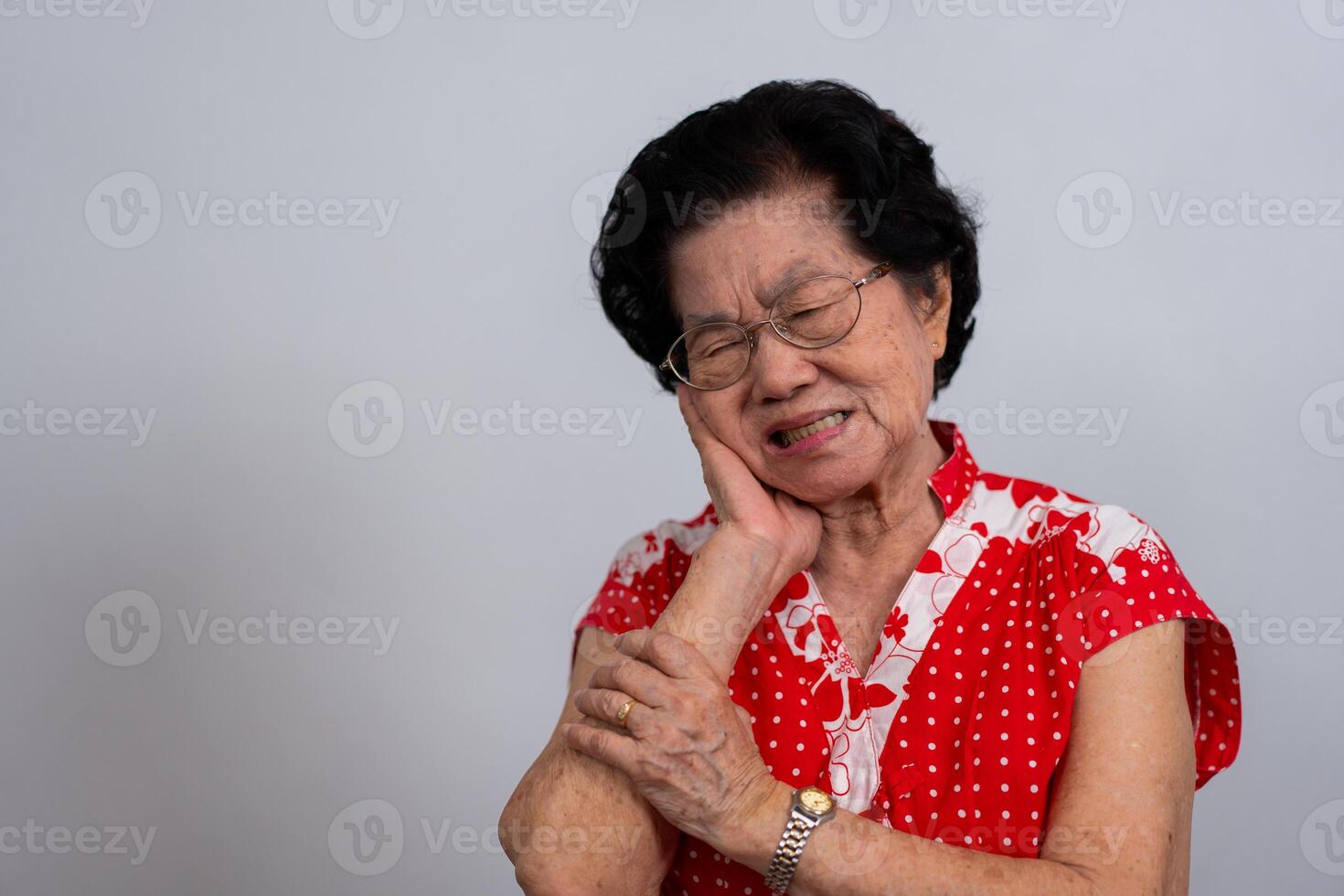 Asie vieux Sénior femme Souffrance de sévère mal aux dents, en portant sa joue et Souffrance fort dentaire douleur sur blanc arrière-plan, dent carie, dent sensibilité, oral santé se soucier concept. photo