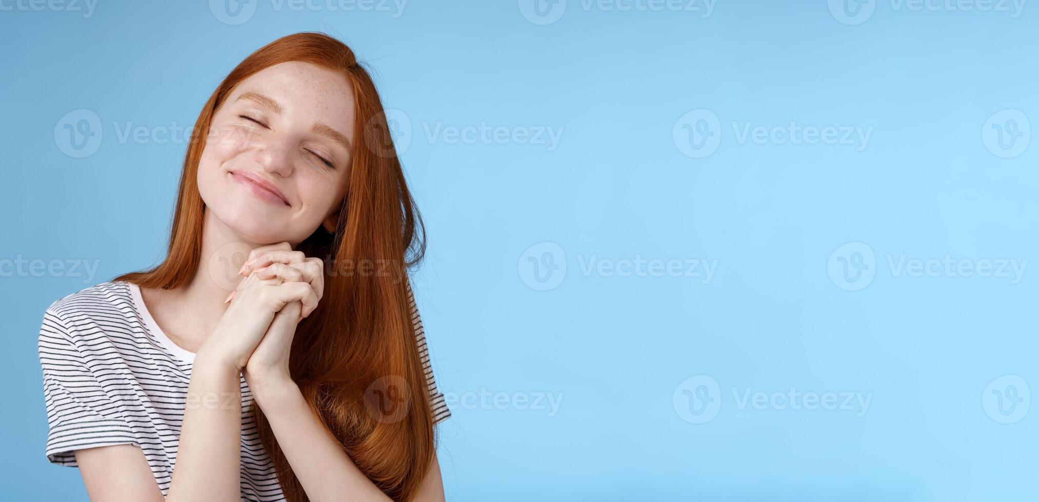 charmant Enchanté content rêveur roux petite amie gingembre longue cheveux basculant tête proche yeux souriant heureux rêverie en pensant à propos sucré soumissionner souvenirs presse paumes ensemble, bleu Contexte photo