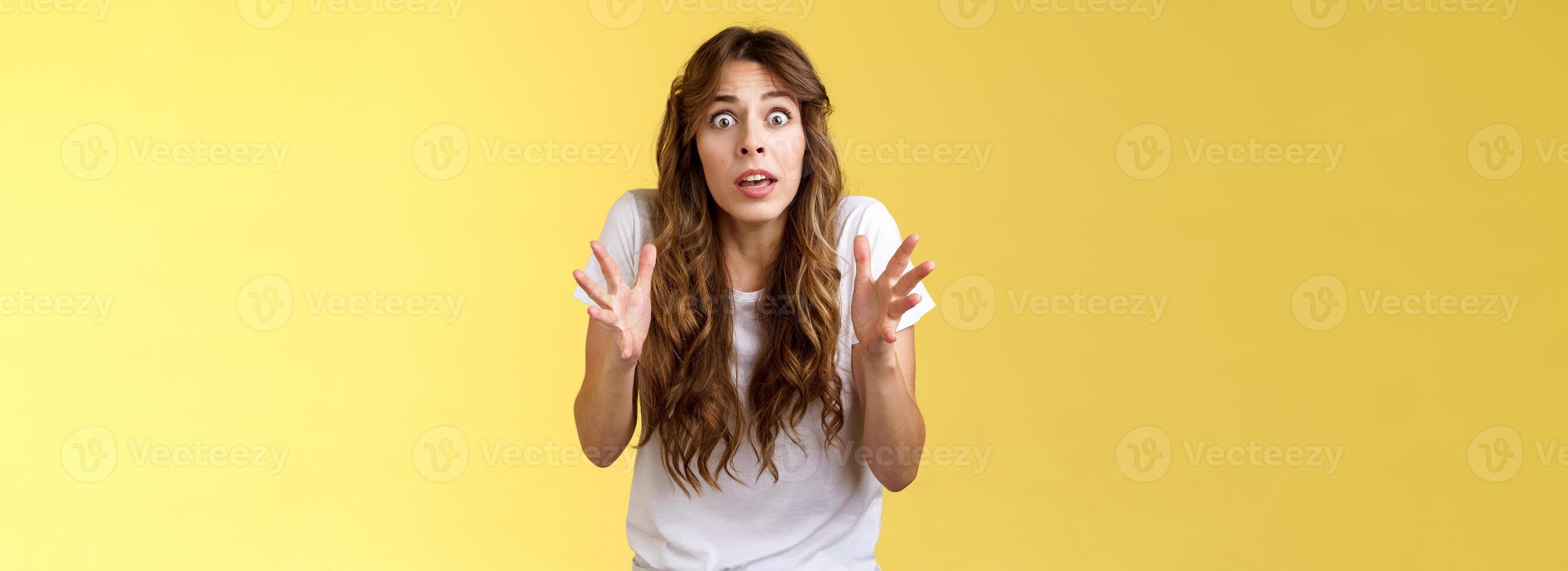 prudent inquiéter pour toi. nerveux peu sûr paniquer troublé Jeune méfiant mignonne caucasien fille frisé la Coupe de cheveux intense regard caméra merlu mains penché anxieux voir terrible situation photo