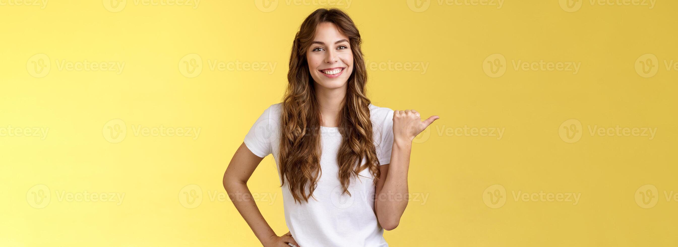 amical sortant de bonne humeur européen mignonne femelle donnant conseils montrant direction animé souriant à pleines dents Heureusement avoir agréable agréable conversation montrer du doigt la gauche pouce présenter promo Jaune Contexte photo