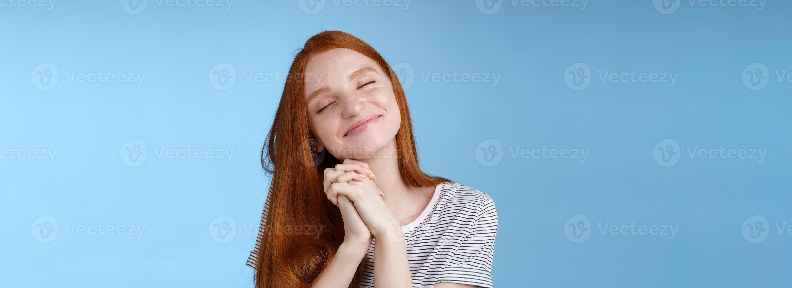 charmant Enchanté content rêveur roux petite amie gingembre longue cheveux basculant tête proche yeux souriant heureux rêverie en pensant à propos sucré soumissionner souvenirs presse paumes ensemble, bleu Contexte photo