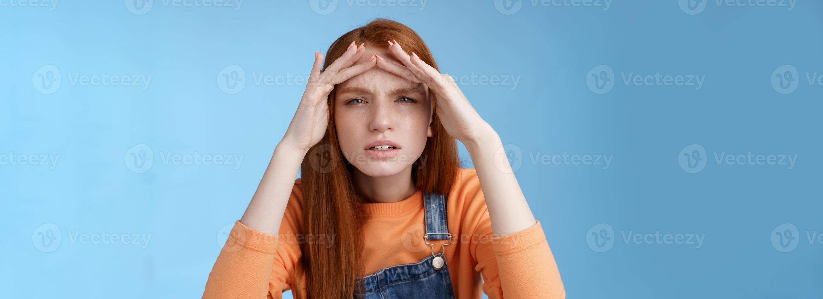 perplexe incertain mignonne marrant roux européen femme recherche Quelqu'un plisser les yeux ne peux pas voir sans pour autant des lunettes pair dans distance tenir mains front couverture vue lumière du soleil, permanent bleu Contexte photo