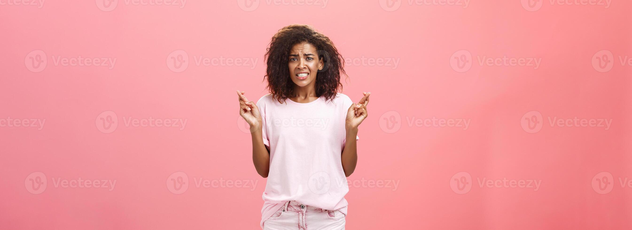 espérer elle obtient positif résultat. portrait de inquiet intense optimiste beau Jeune africain américain femelle collaborateur renfrogné serrant les dents et traversée les doigts pour bien la chance tandis que fabrication souhait photo