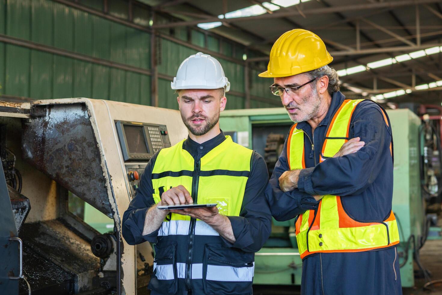 deux ingénieur Regardez projets et Planification avec tablette mobile dans usine photo