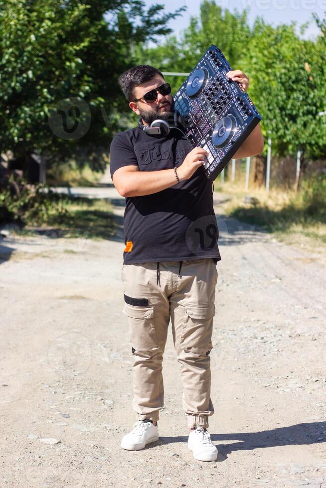 dj avec écouteurs et mixer dans le parc, le dj à travail photo