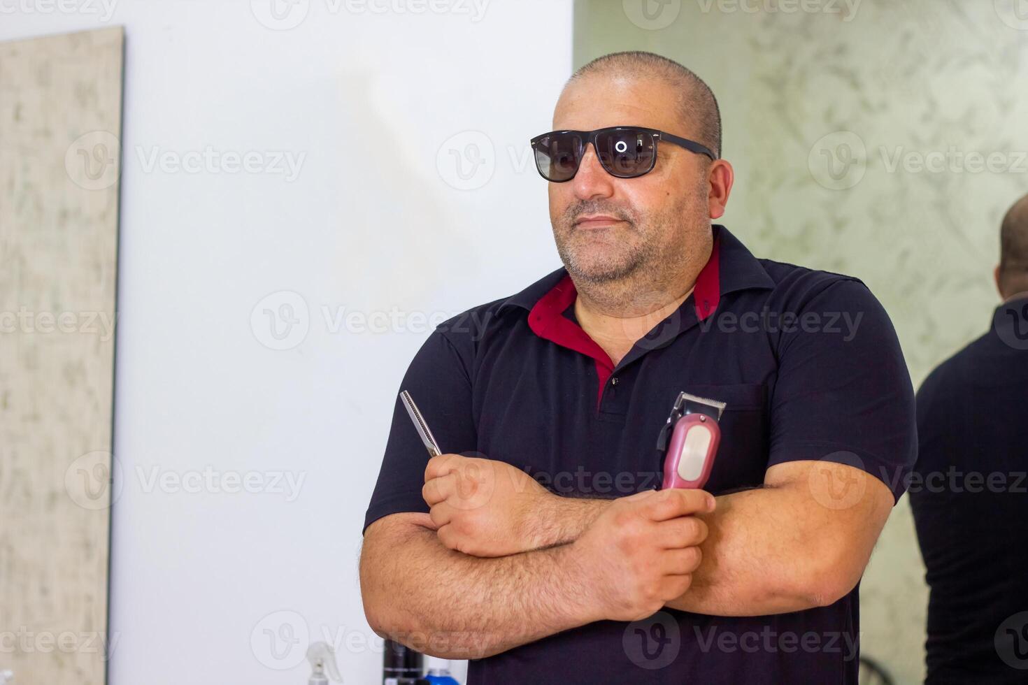 Jeune homme avec des lunettes de soleil dans coiffeur magasin photo