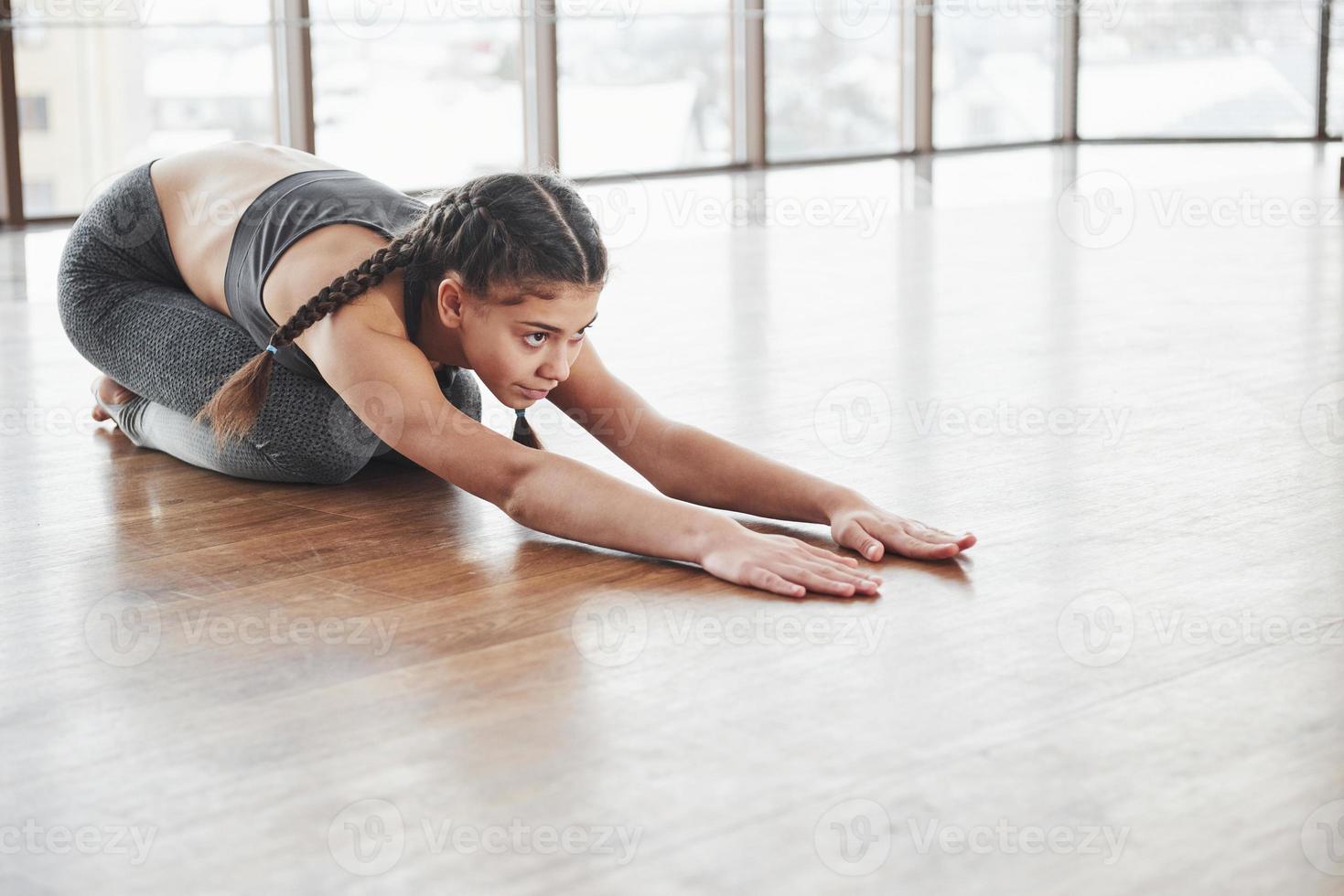 réchauffer sur le parquet. jeune fille fitness se prépare pour une session photo