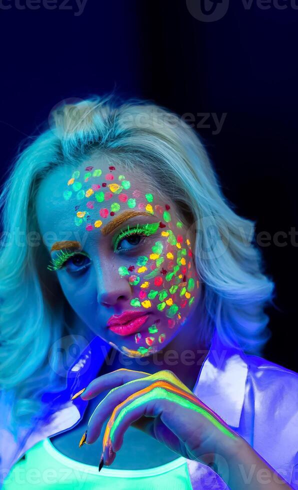 portrait de une femme avec peint affronter, femme avec uv maquillage dans studio, portrait de une femme dans carnaval masque, le femme est décoré dans une ultra-violet poudre photo