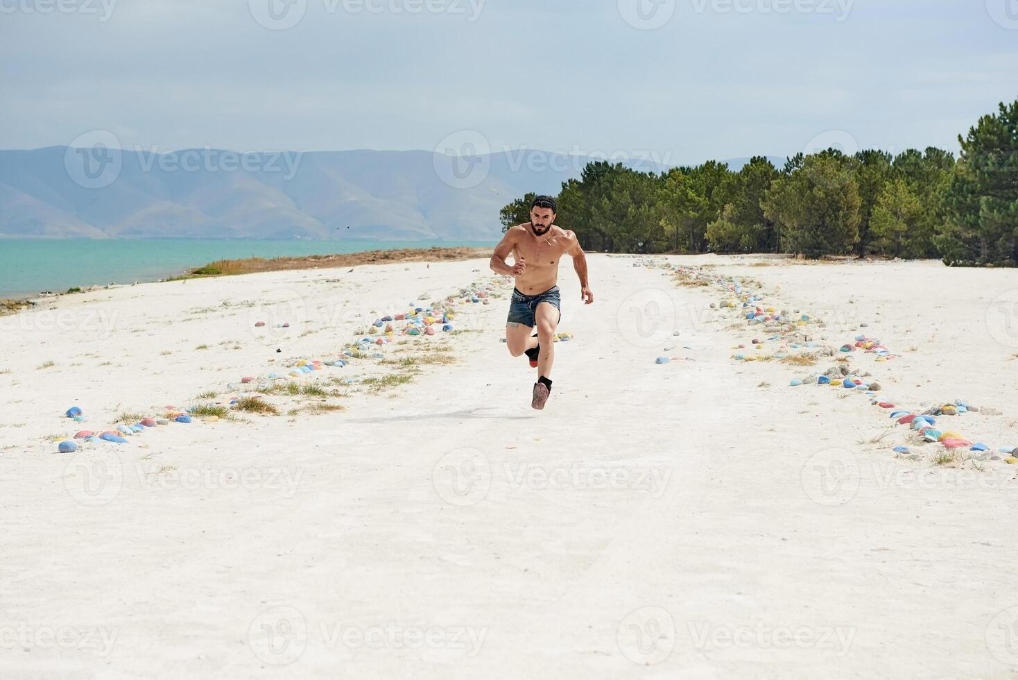 Jeune musclé homme exercice sur le plage, Jeune musclé homme Faire musculation des exercices sur le plage, athlétique Jeune homme sur le plage photo
