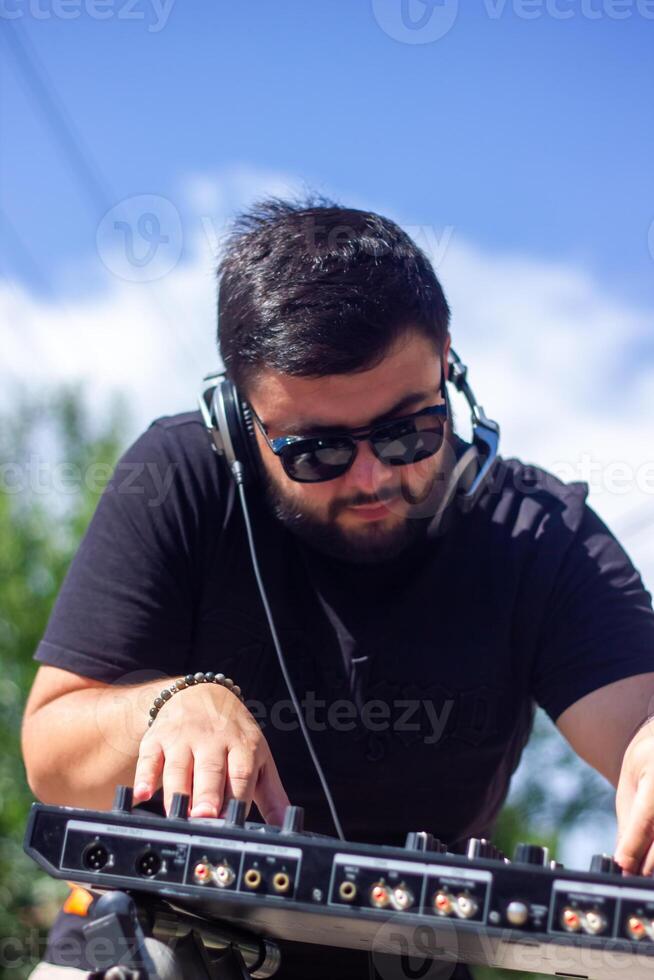 dj avec écouteurs et mixer dans le parc, le dj à travail photo