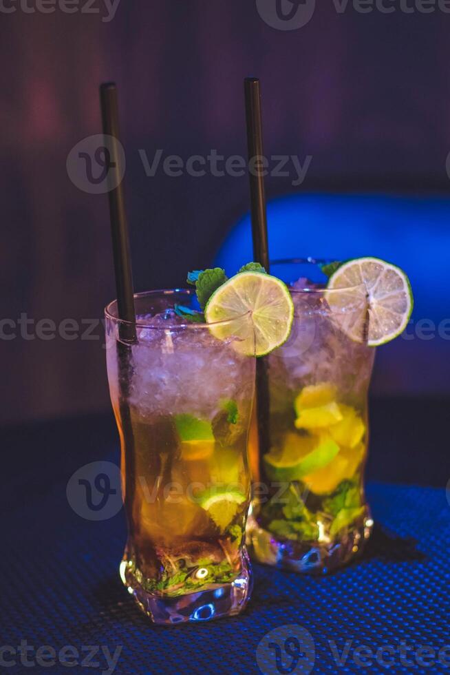 des cocktails avec chaux, menthe et la glace sur bleu tableau. photo