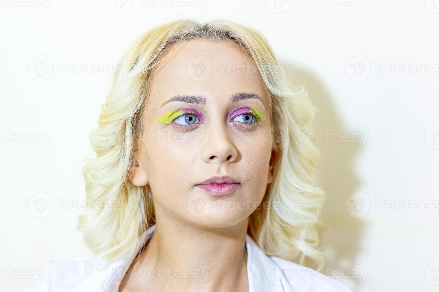 jolie Jeune femme appliquant faire en haut dans beauté salon photo