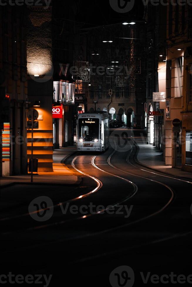 verticale photo photographier de tram dans ville lumières à nuit avec Jaune lumières