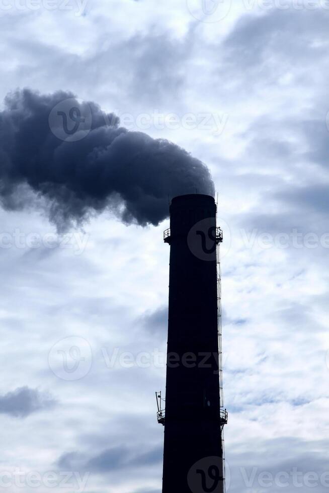 cheminée de industriel plante contaminer air en dessous de nuageux ciel photo