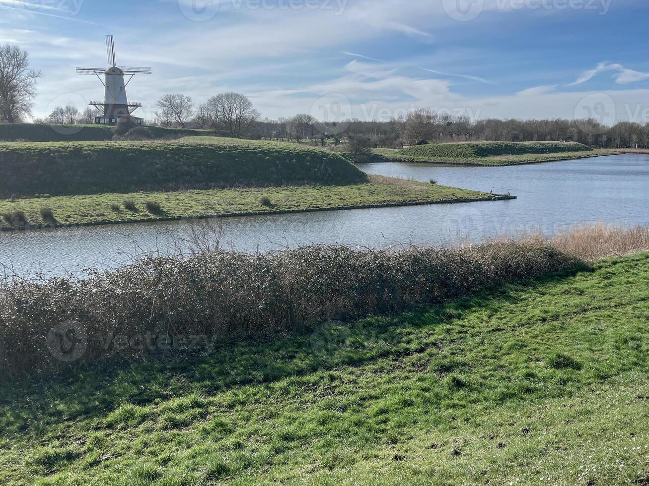 paysage avec canal et Moulin à vent dans le Pays-Bas photo