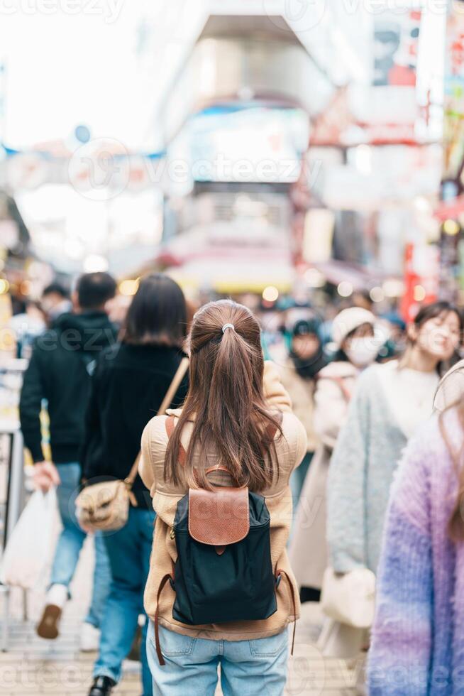 touristique femme visite ameyoko marché, une occupé marché rue situé dans ueno. point de repère et populaire pour touristique attraction et Voyage destination dans Tokyo, Japon et Asie concept photo