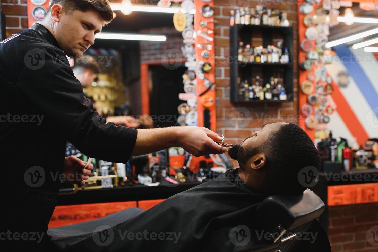 africain Masculin client avoir la Coupe de cheveux à coiffeur magasin de professionnel coiffeur. photo