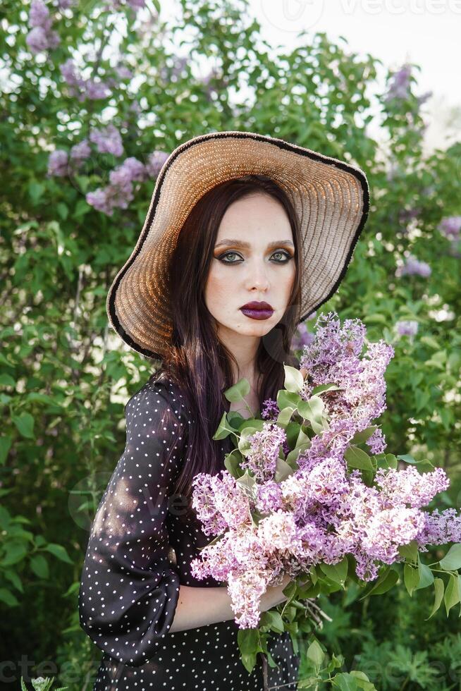 une à la mode fille avec foncé cheveux, une printemps portrait dans lilas tons dans été. brillant professionnel se maquiller. photo