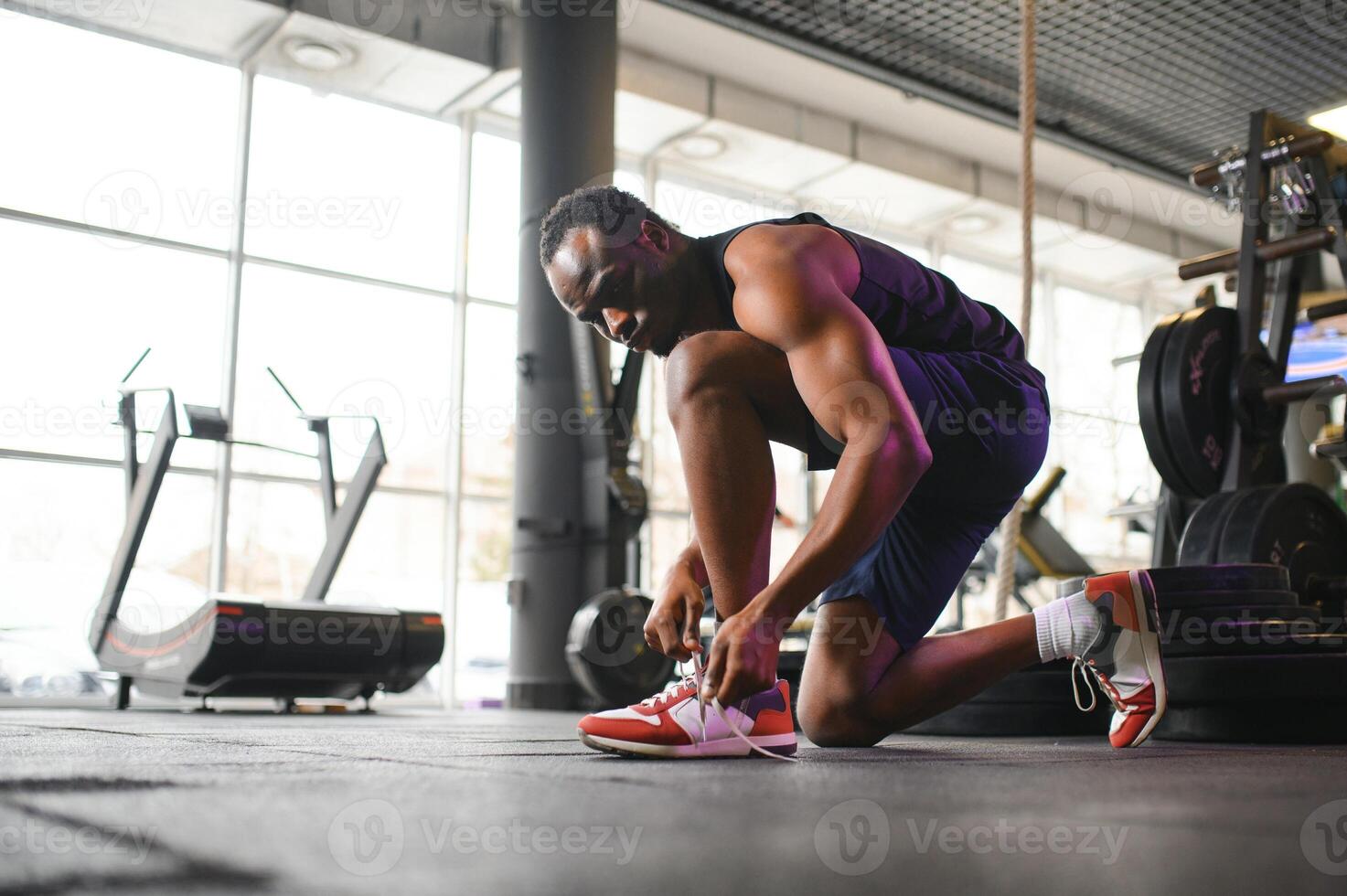 africain homme attacher les lacets à baskets dans le Gym photo