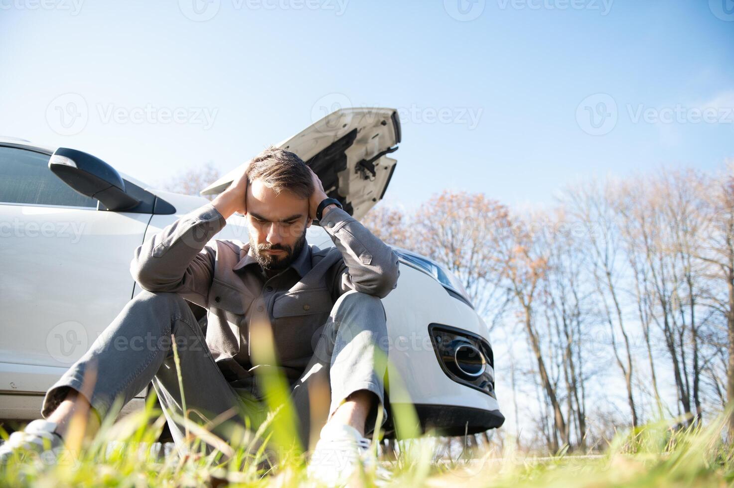 triste chauffeur en portant le sien tête ayant moteur problème permanent près cassé voiture sur le route. voiture panne concept photo