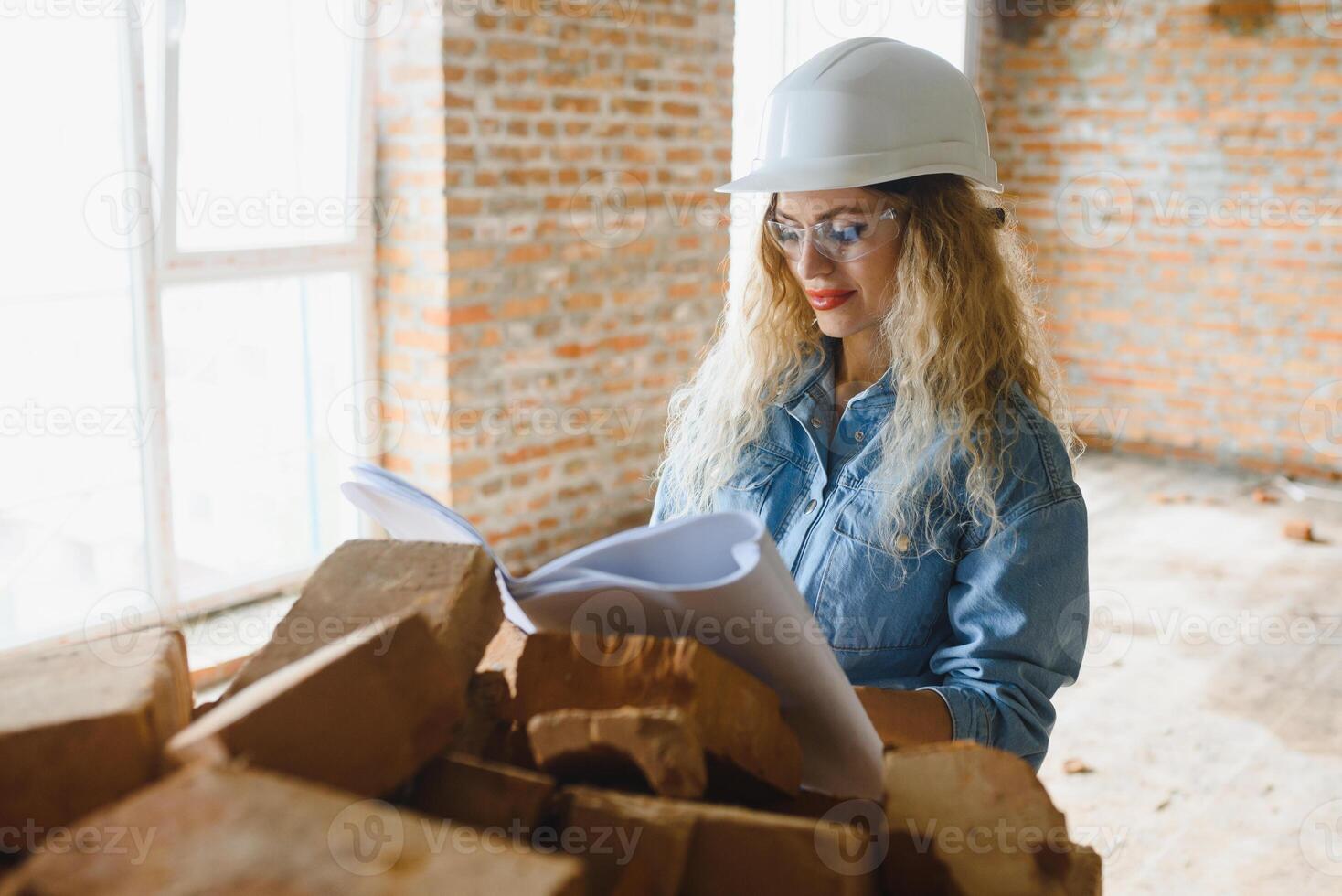 construction concept. jolie femelle constructeur dans salopette et casque travail sur construction placer. photo