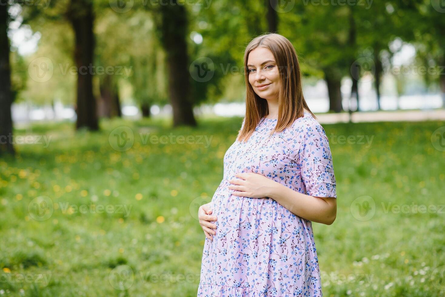 le Enceinte fille sur marcher dans ville parc photo