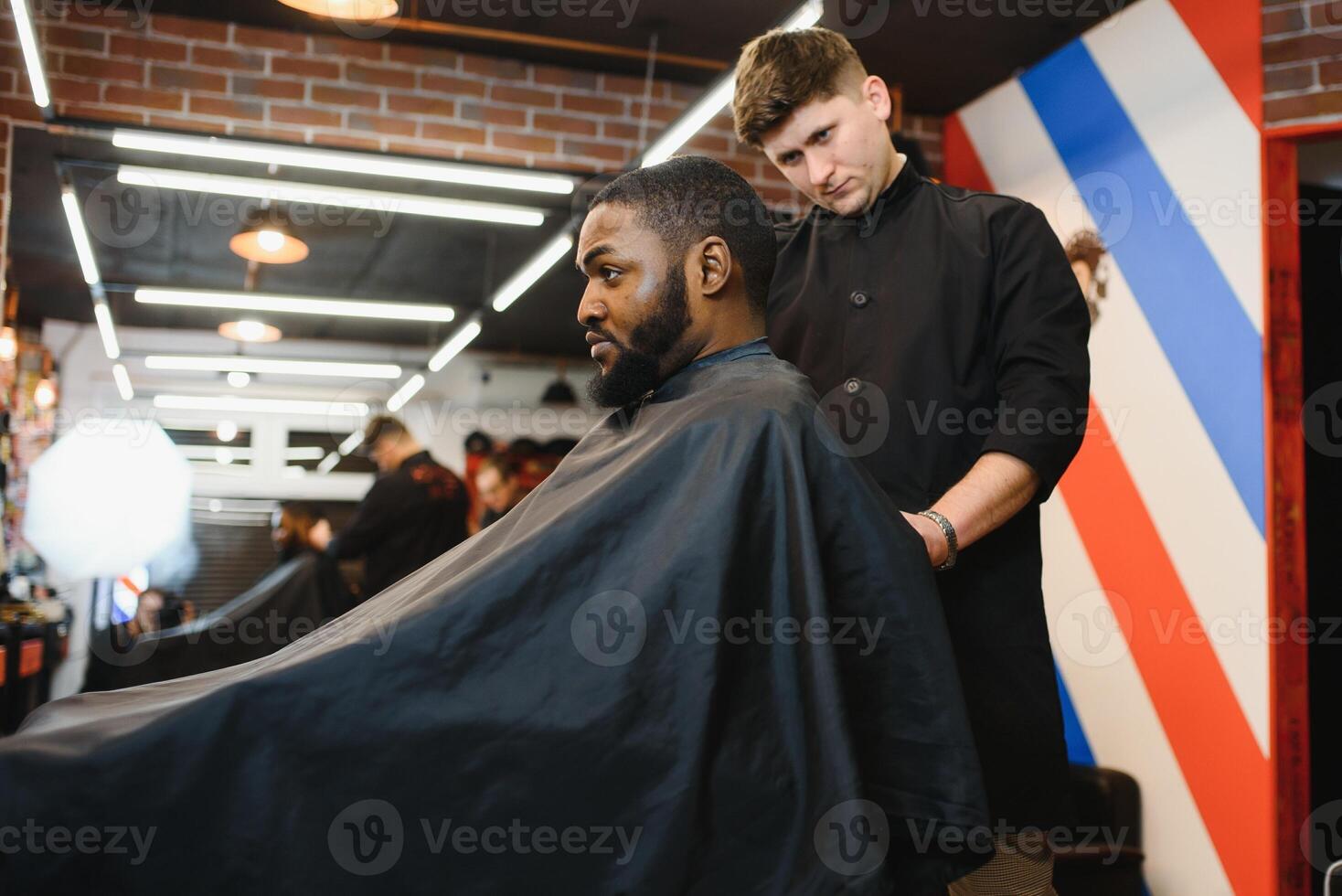 Jeune Afro-américain homme visite salon de coiffure photo