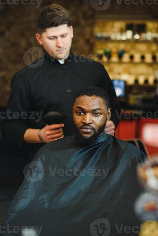 visite salon de coiffure. africain américain homme dans une élégant coiffeur magasin photo