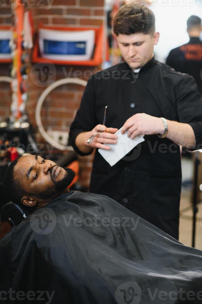 visite salon de coiffure. africain américain homme dans une élégant coiffeur magasin photo