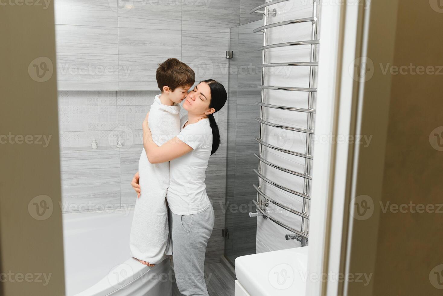 mère la lessive peu fils dans salle de bains photo