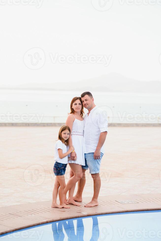 content famille, été repos près le bassin. père mère et fille photo