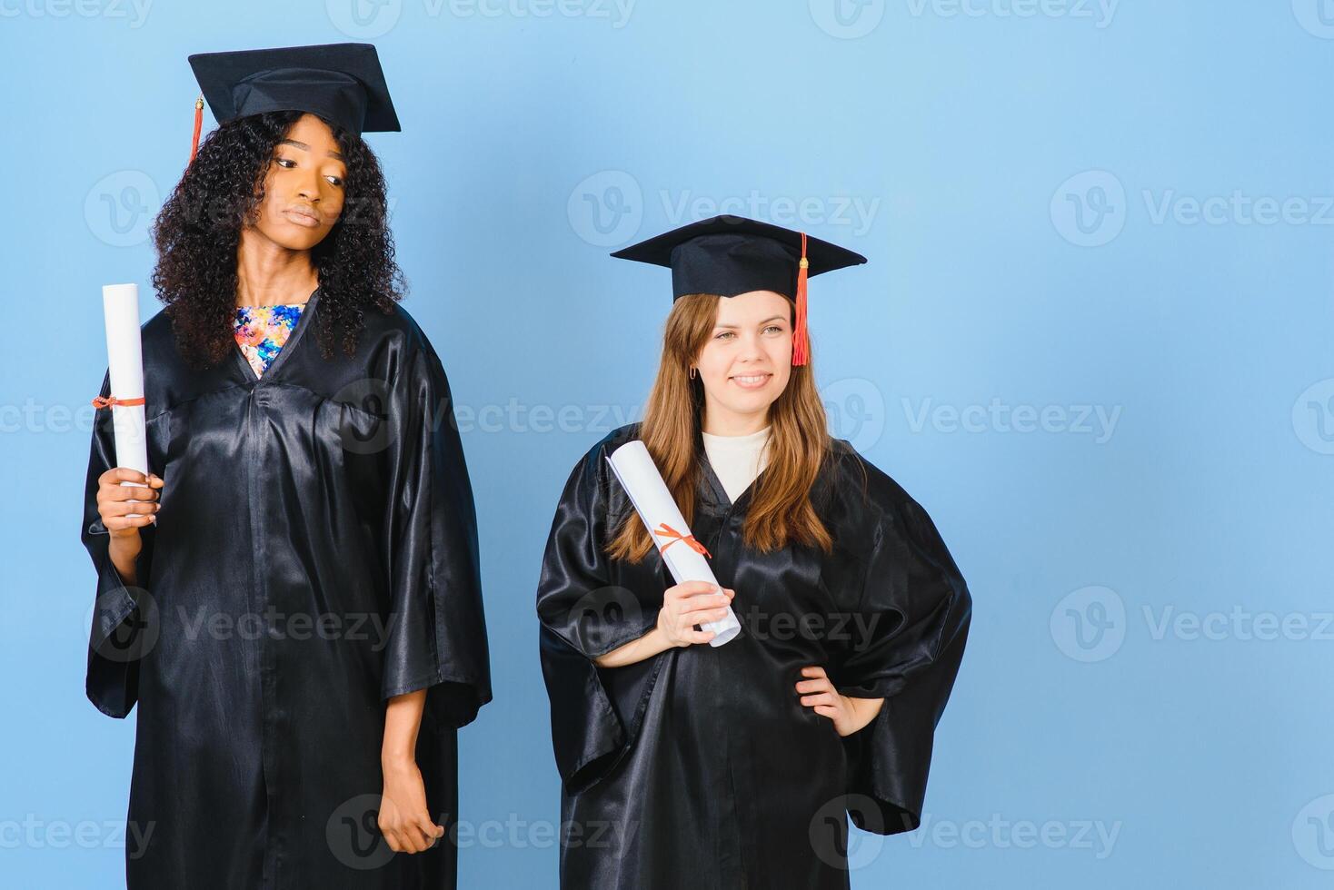 deux Jeune femmes célébrer leur l'obtention du diplôme avec diplômes photo