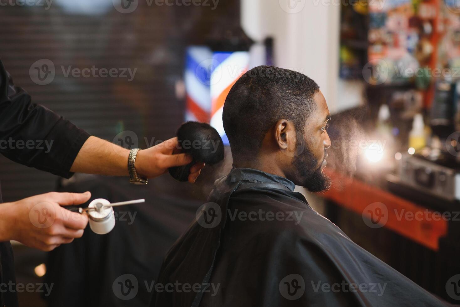 africain Masculin client avoir la Coupe de cheveux à coiffeur magasin de professionnel coiffeur. photo