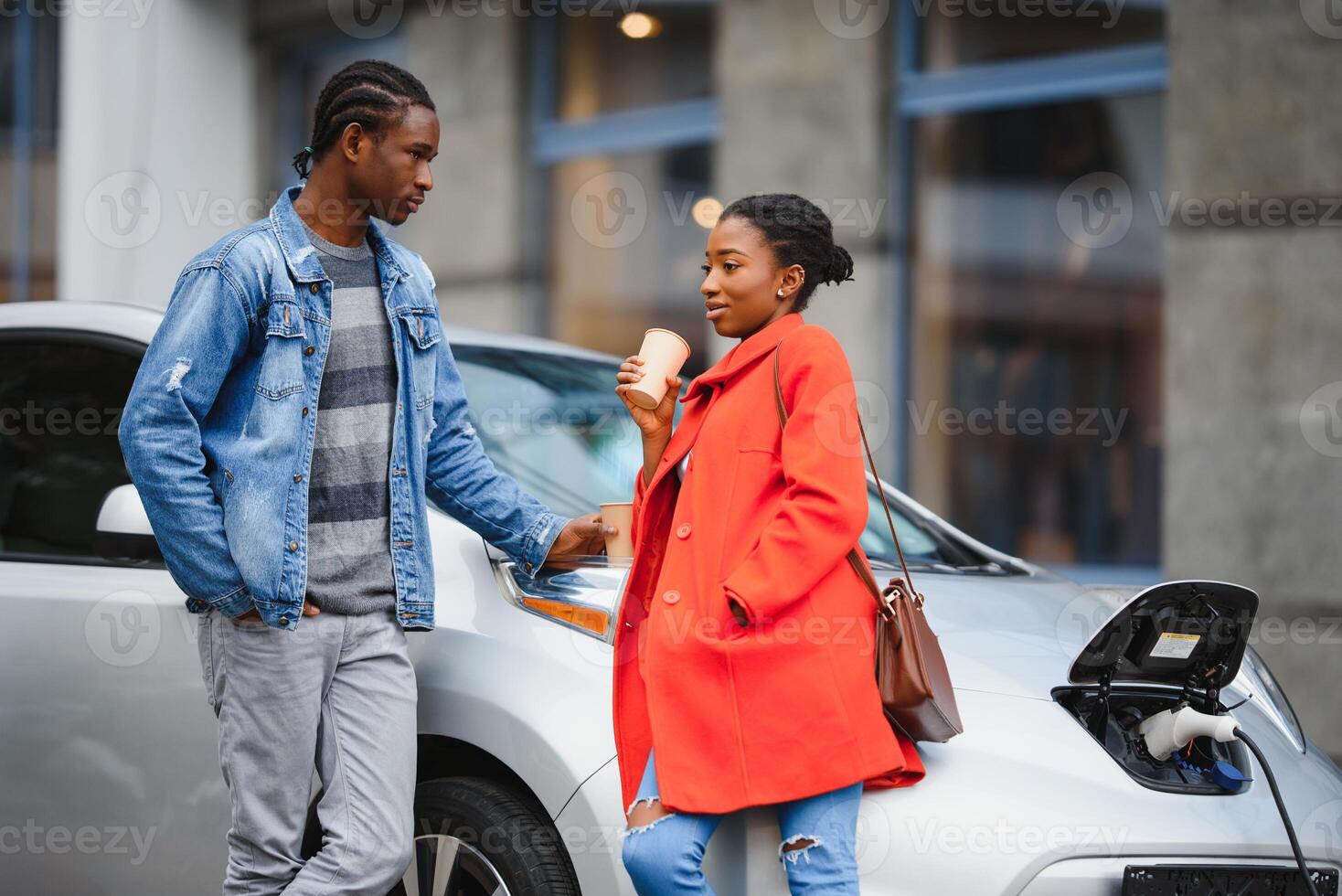 content Jeune adulte africain américain homme et souriant femme mise en charge électrique auto. photo