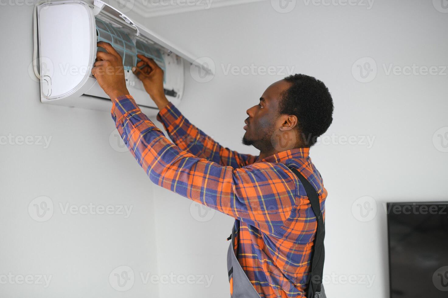 africain américain électricien réparer air Conditionneur à l'intérieur photo
