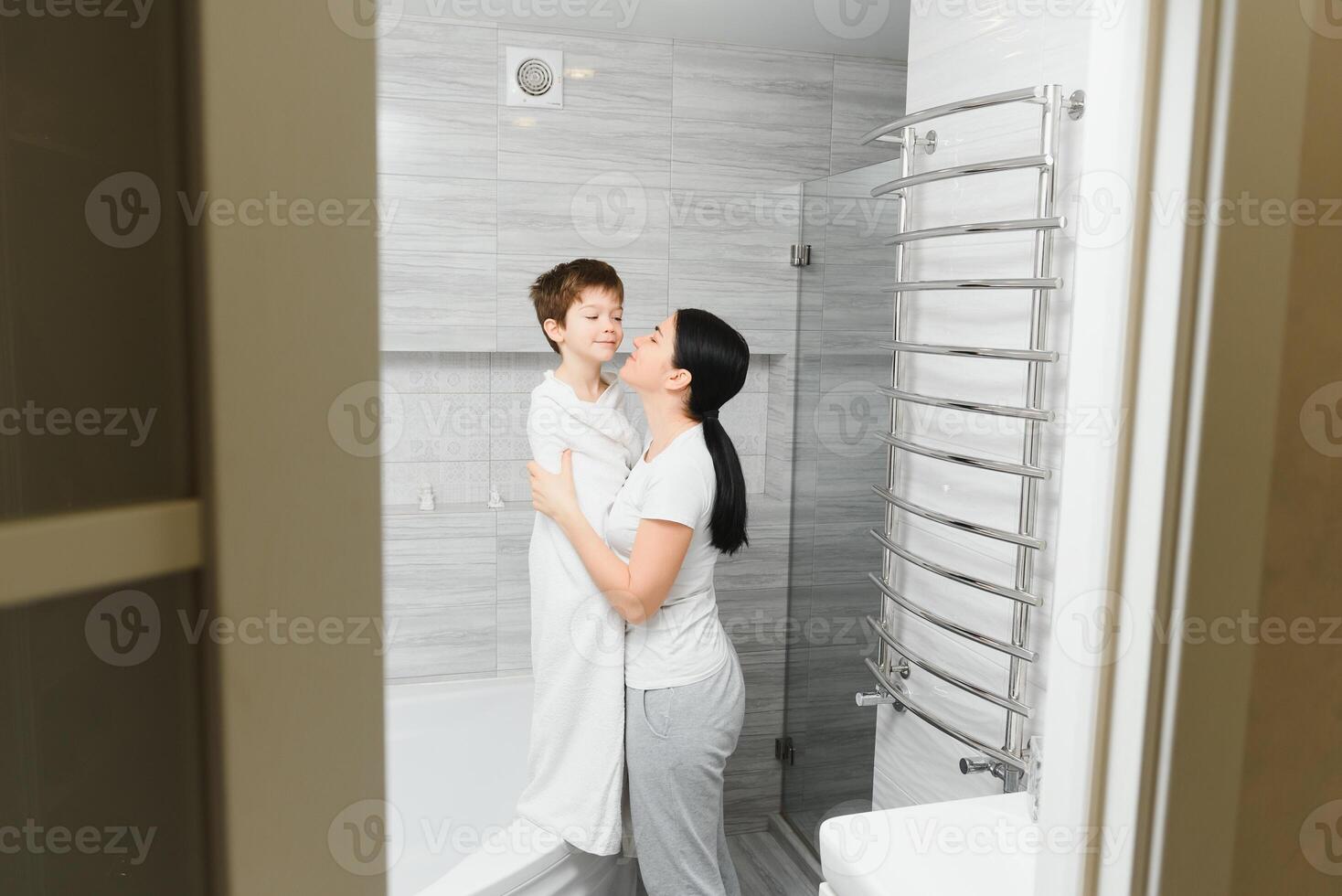 mère la lessive peu fils dans salle de bains photo