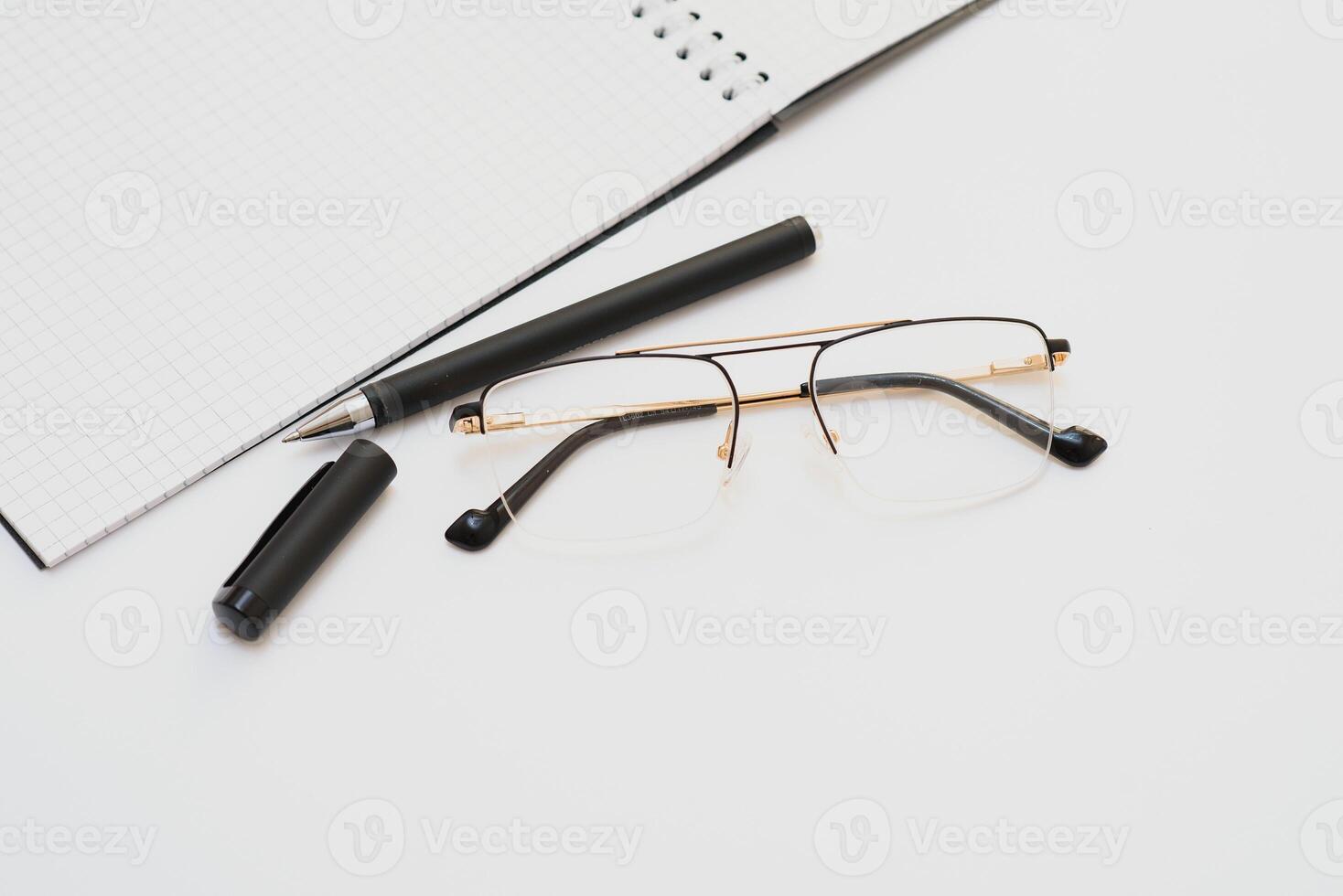 un cahier vierge avec un stylo se trouve sur le dessus de la table de bureau blanche. vue de dessus avec espace de copie, mise à plat. photo